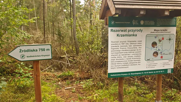 Drogowskaz „Źródliska 750 m” i tablica rezerwatu.